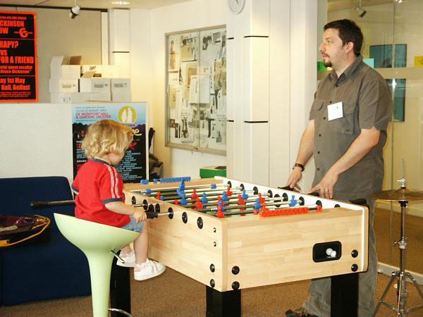 Miss Edie Pattison, learning how to play table football from her father